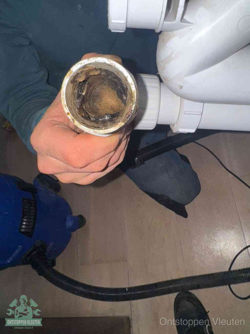 Een losgekoppeld PVC-afvoerbuisstuk dat van binnen volledig is dichtgeslibd met vet en vuil, de meest voorkomende oorzaak van verstoppingen in Vleuten