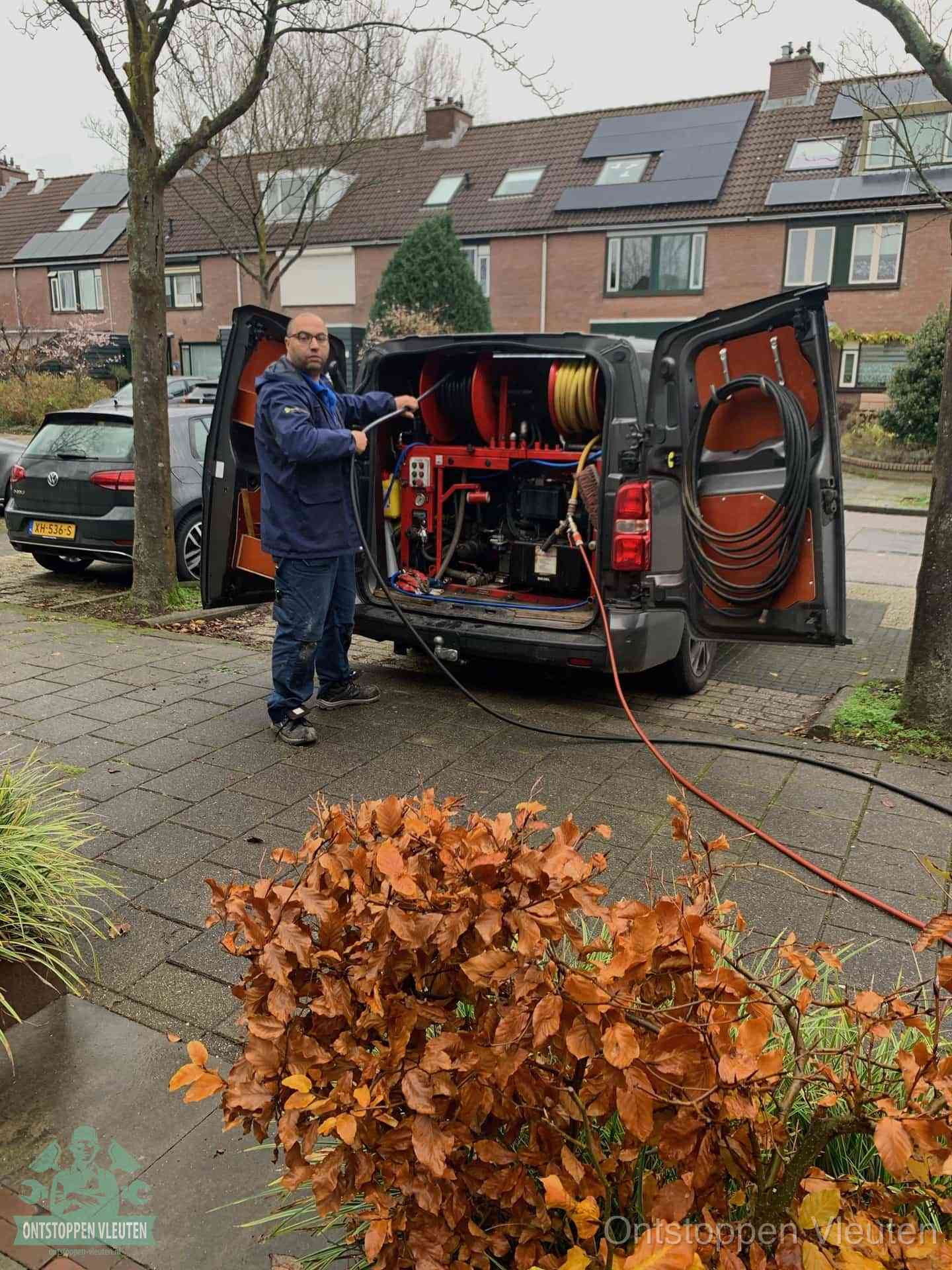 Een monteur staat bij zijn open bestelbus met hogedruk-rioolreinigingsapparatuur, klaar om binnen 30 minuten uit te rukken voor een spoedverstopping in Vleuten