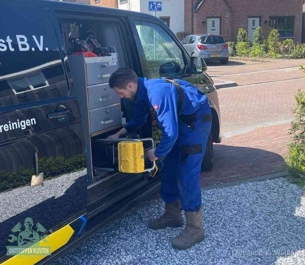 Een monteur pakt gereedschap uit de bedrijfsbus, het moment om een professionele ontstoppingsdienst in te schakelen in Vleuten