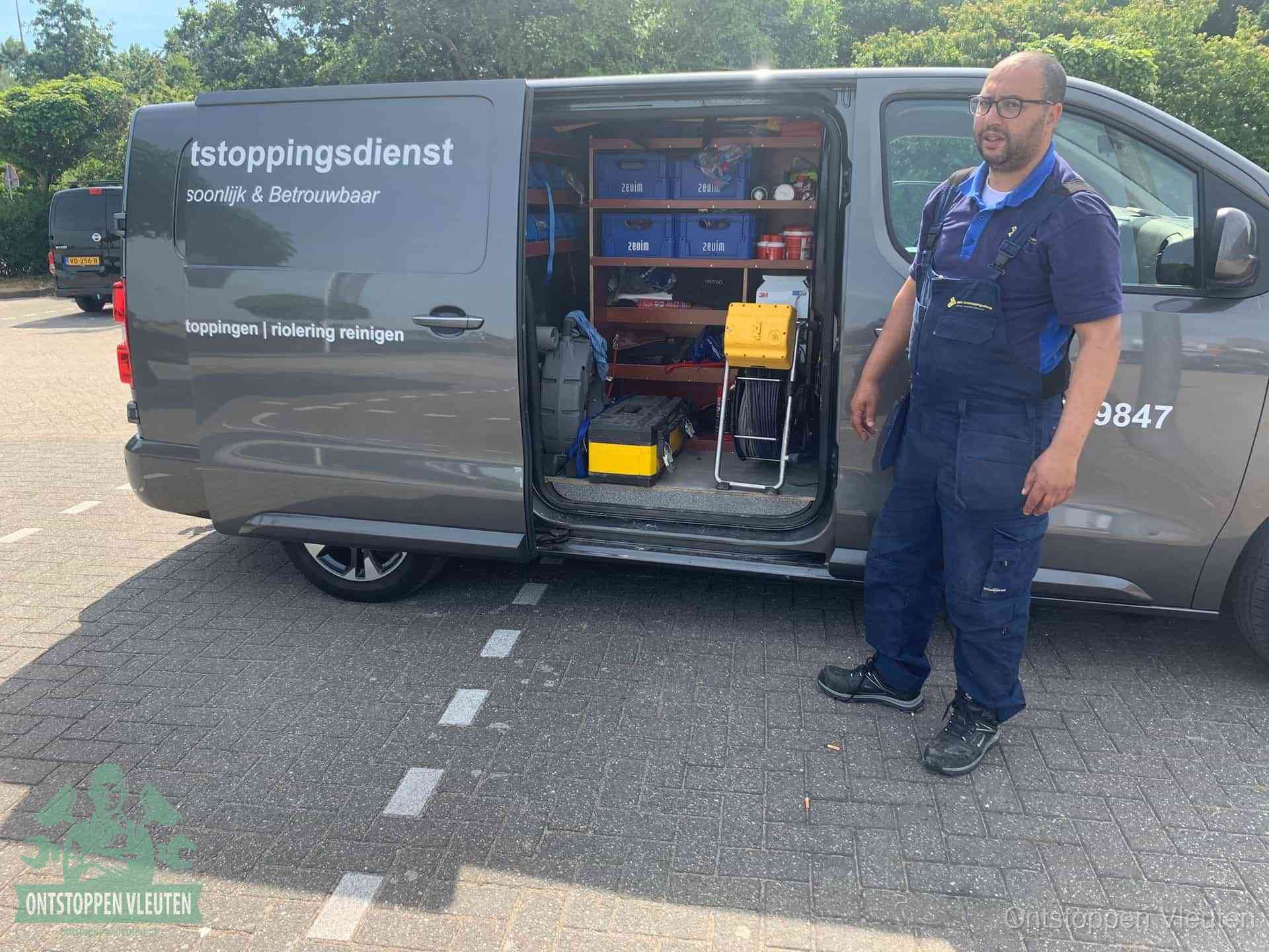 Een monteur staat klaar bij zijn bedrijfsbus met gereedschap, de vaste werkwijze van de ontstoppingsdienst in Vleuten